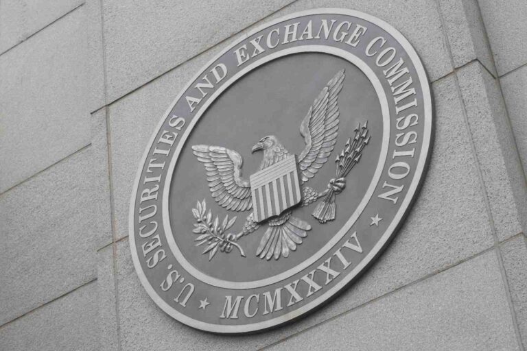 SEC commissioners in a meeting room with papers and documents related to cryptocurrency rulemaking spread across the table