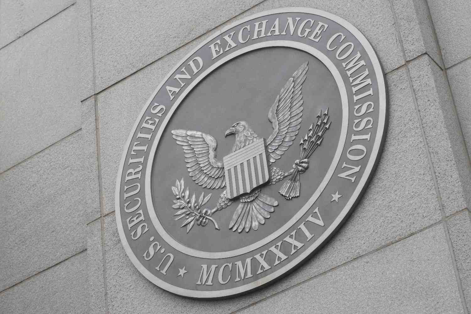 SEC commissioners in a meeting room with papers and documents related to cryptocurrency rulemaking spread across the table