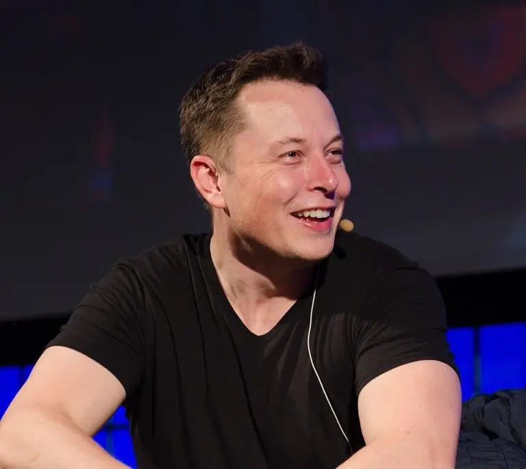 A laptop screen displays SpaceX's AI Division rebranding from SpaceXAI to SpaceXSI during a company presentation